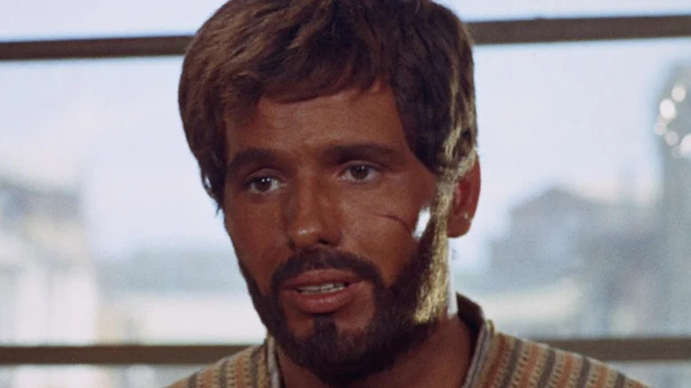Ringo (Giuliano Gemma) stands speaking in front of a window in The Return of Ringo