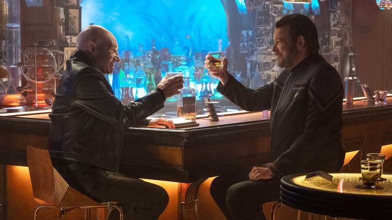 Jean-Luc Picard (Patrick Stewart) toasts Will Riker (Jonathan Frakes) in a bar in Star Trek: Picard
