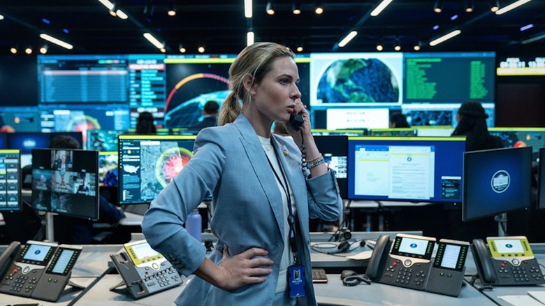 Rebecca Ferguson as Captain Olivia Walker is on the phone in a busy White House Situation Room