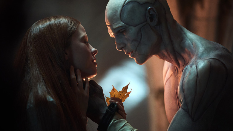 Mia Goth as Elizabeth holding a leaf while Jacob Elordi as the Creature holds her face tenderly in Frankenstein