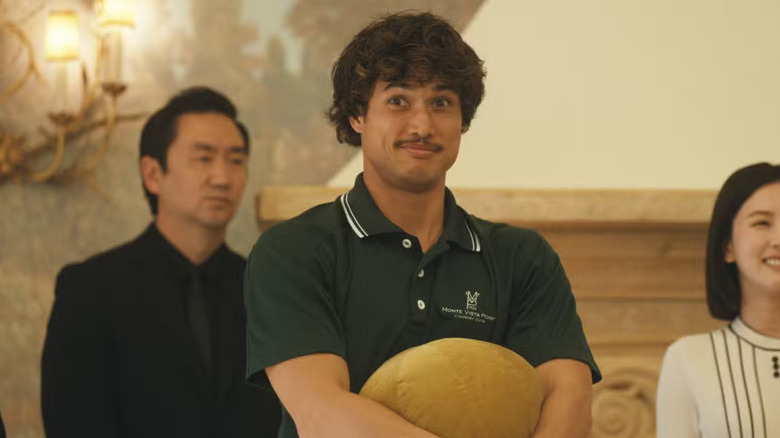 Charles Melton as Austin Davis in Beef, wearing a country club polo and giving an awkward smile.