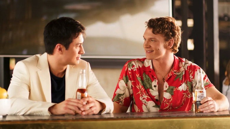 Hudson Williams as Shane Hollander and Connor Storrie as Ilya Rozanov talk in a bar in Heated Rivalry