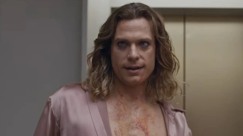 Sam Reid as Lestat de Lioncourt in The Vampire Lestat, wearing a silk robe open and barely showing his fangs.
