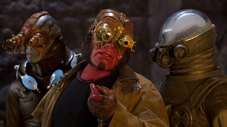 Hellboy (Ron Perlman) speaks with Abe Sapien (Doug Jones) and Johann Krauss