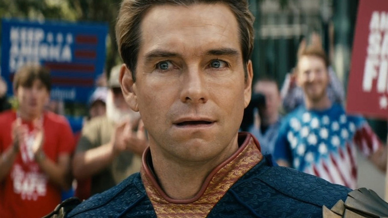 Homelander (Antony Starr) stands visibly stunned surrounded by supporters in The Boys