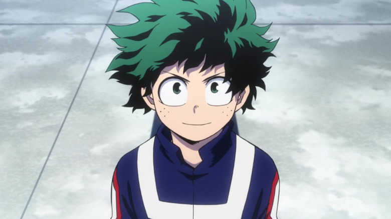 Izuku Midoriya stands smiling while looking up in My Hero Academia