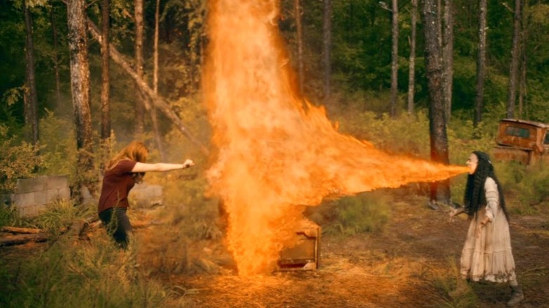 Danielle Rose Russell as Hope Mikaelson guards herself from flames coming from Lauren Ridloff as a human dragon on Legacies