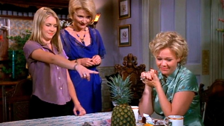 Melissa Joan Hart as Sabrina, Beth Broderick as Zelda, and Caroline Rhea as Hilda stare at a pineapple on Sabrina the Teenage Witch