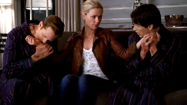 Alexander Skarsgård as Eric Northman and Stephen Moyer as Bill Compton feed on Anna Paquin as Sookie Stackhouse on True Blood