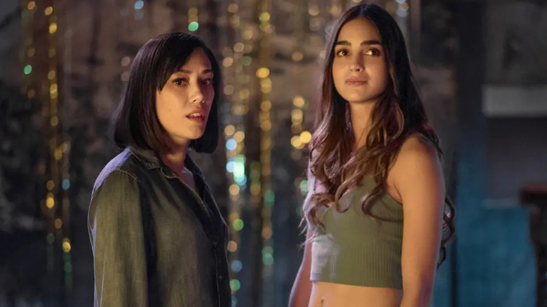 Emma Hernandez (Mishel Prada) and Lyn Hernandez (Melissa Barrera) stand in a decorated room in Vida