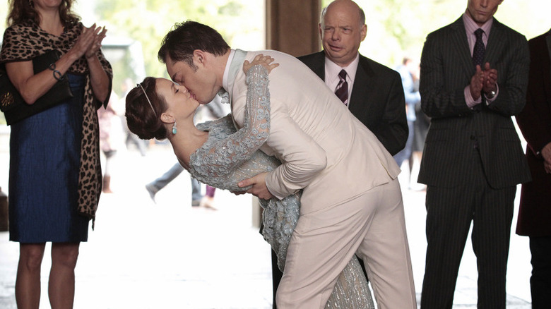 Chuck Bass (Ed Westwick) dips and kisses Blair Waldorf (Leighton Meester) as Cyrus (Wallace Shawn) watches in Gossip Girl