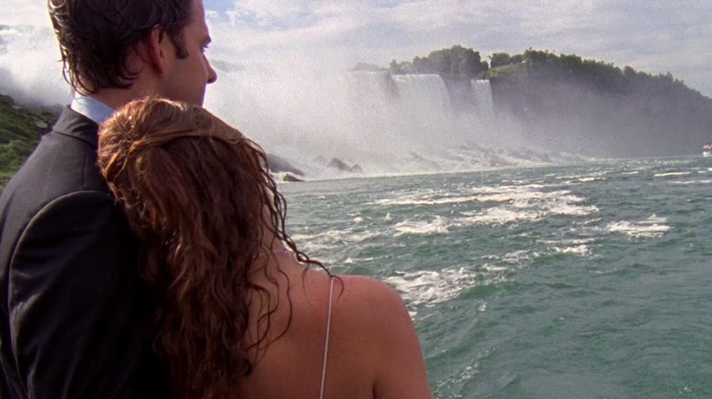 Jim Halpert (John Krasinski) and Pam Beesly (Jenna Fischer) hold each other while observing the Niagara Falls in The Office (2005)