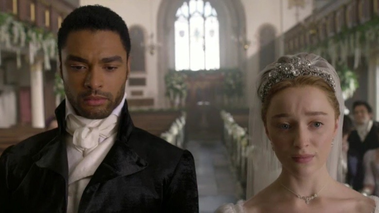 Simon Basset (Regé-Jean Page) and Daphne Bridgerton (Phoebe Dynevor) stand together in a church for their wedding in Bridgerton