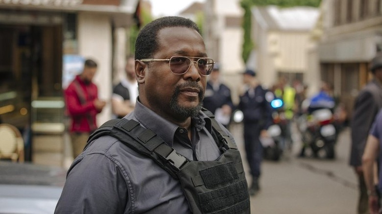 Wendell Pierce's James Greer wearing a bulletproof vest and sunglasses in Jack Ryan