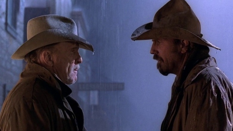 Boss Spearman (Robert Duvall) speaks to Charley Waite (Kevin Costner) in the pouring rain in Open Range