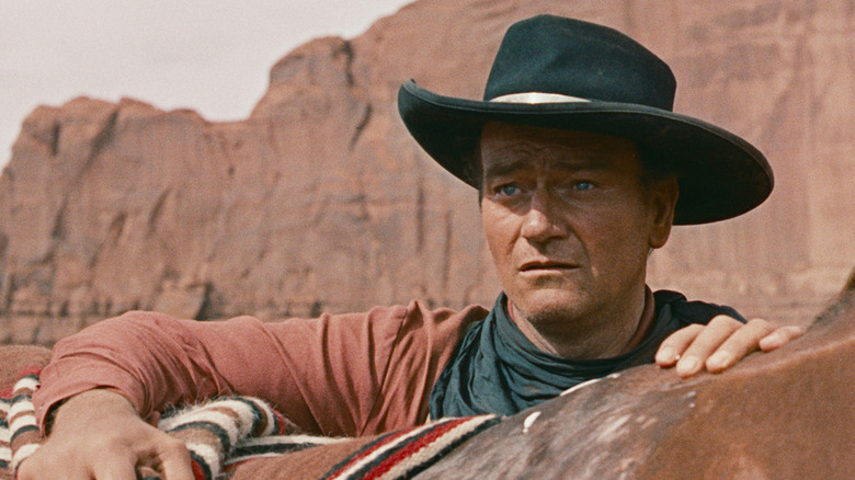 Ethan Edwards (John Wayne) glances over his horse in The Searchers