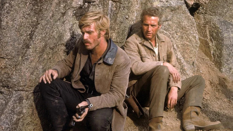 The Sundance Kid (Robert Redford) and Butch Cassidy (Paul Newman) hide behind a rock in Butch Cassidy and the Sundance Kid