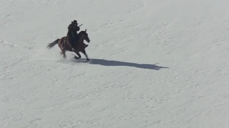 Silence (Jean-Louis Trintignant) rides a horse through the snow in The Great Silence