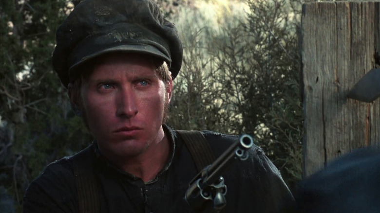 Emilio Estevez as Billy the Kid drawing a pistol and glaring in Young Guns