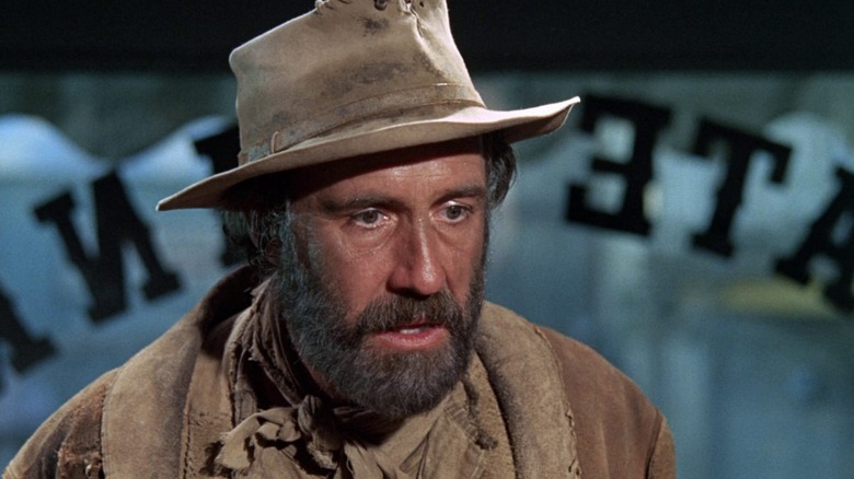 Cable Hogue (Jason Robards) stands incredulously inside of a storefront window in The Ballad of Cable Hogue