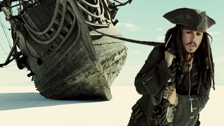 Johnny Depp as Jack Sparrow drags a boat through the desert in Pirates of the Caribbean: At World's End