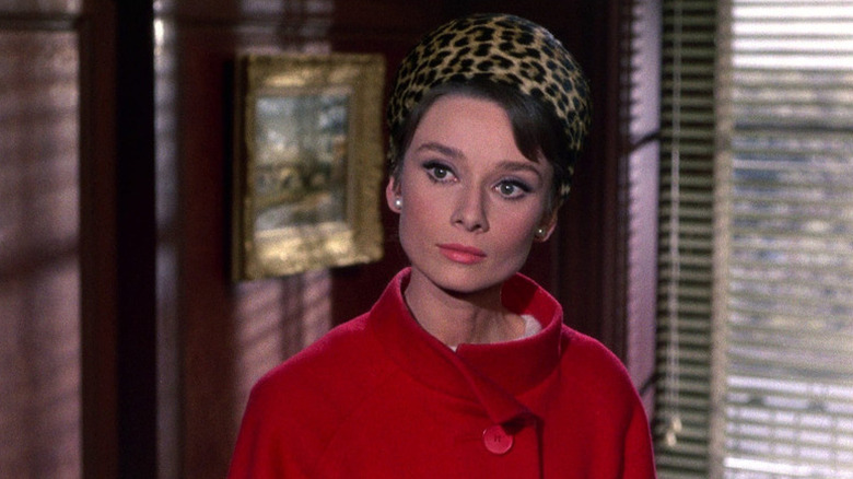 Reggie Lampert (Audrey Hepburn) stands in an office in Charade
