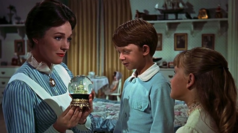 Mary Poppins (Julie Andrews) shows a snow globe to Michael Banks (Matthew Garber) and Jane Banks (Karen Dotrice) in Mary Poppins