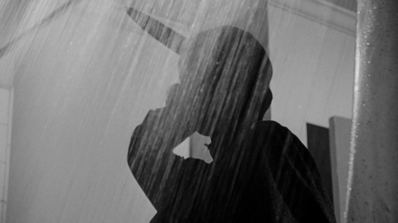 Norman Bates (Anthony Perkins) prepares to stab someone in the shower in Psycho (1960)