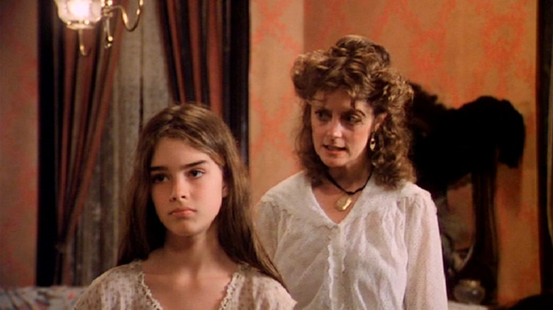 Brooke Shields as Violet and Susan Sarandon as Hattie in Pretty Baby, as Hattie speaks to Violet from behind her while Violet looks annoyed.