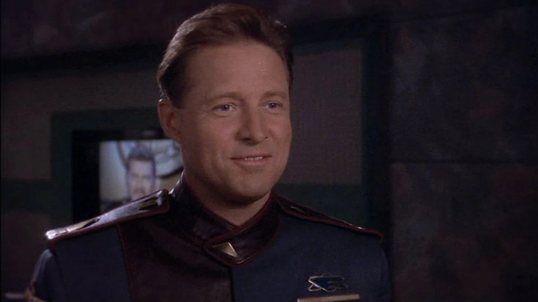 John Sheridan (Bruce Boxleitner) stands smiling in Babylon 5
