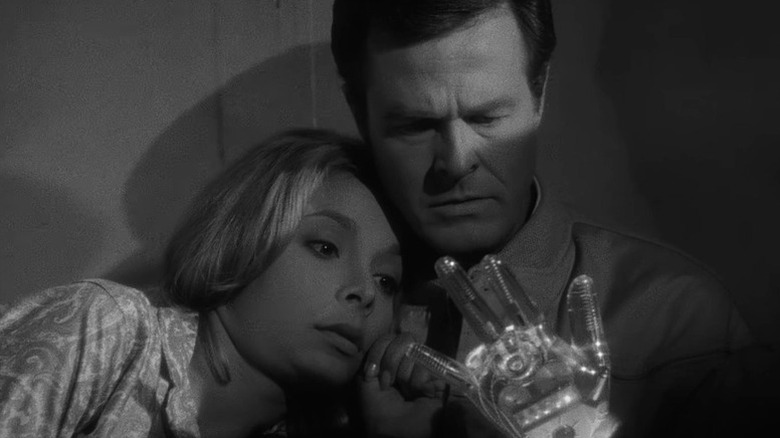 Consuelo Biros (Arlene Martel) and Trent (Robert Culp) stare at a mechanical hand in The Outer Limits (1963)