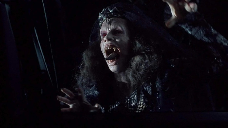 Amelia Kinkade as possessed Angela making a scary face with her tongue out and hands up in Night of the Demons