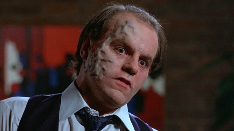 Michael Ironside as Darryl Revok looking wide-eyed and tilting his head to the side as the veins on the left side of his face bulge unnaturally in Scanners