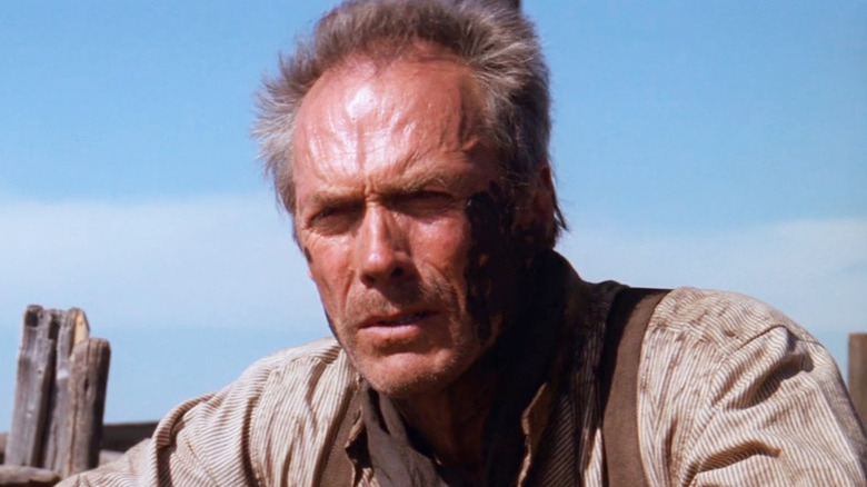 Will Munny (Clint Eastwood) leans against a fence in Unforgiven (1992)