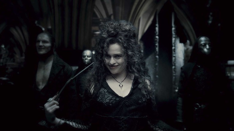 Helena Bonham Carter as Bellarix Lestrange in Harry Potter and the Half Blood Prince, with Dave Legeno as Fenrir Greyback standing behind her along with other masked Death Eaters.