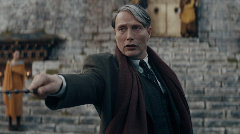 Mads Mikkelsen as Gellert Grendelwald in Fantastic Beasts: The Secrets of Dumbledore, raising his wand.
