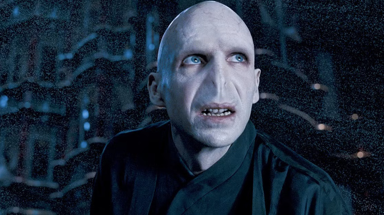Ralph Finnes as Voldemort in Harry Potter and the Order of the Phoenix, looking off menacingly while surrounded by dust particles.
