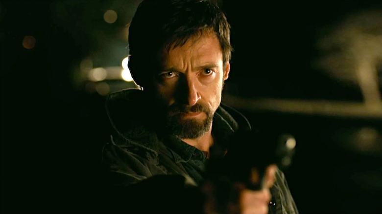 Hugh Jackman as Keller Dover holding a gun in Prisoners