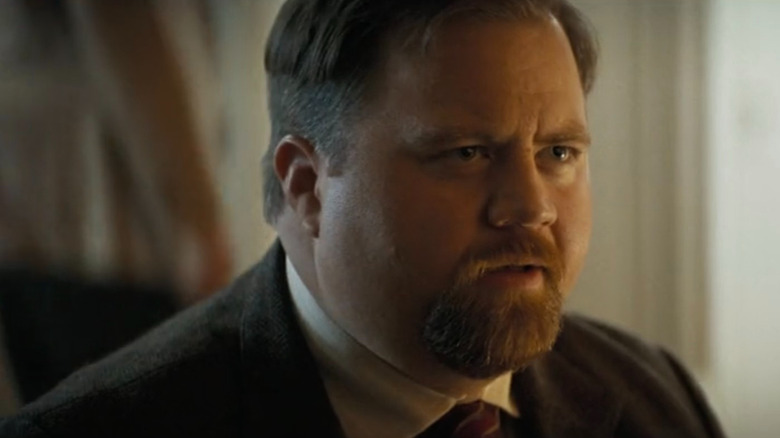 Ed Hocken Jr. (Paul Walter Hauser) kneeling in The Naked Gun