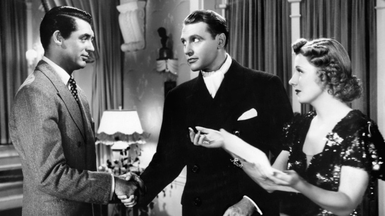 Cary Grant as Jerry shaking hands with a skeptcial Ralph Bellamy as Dan Leesonand as Irene Dunne as Lucy looks on in The Awful Truth