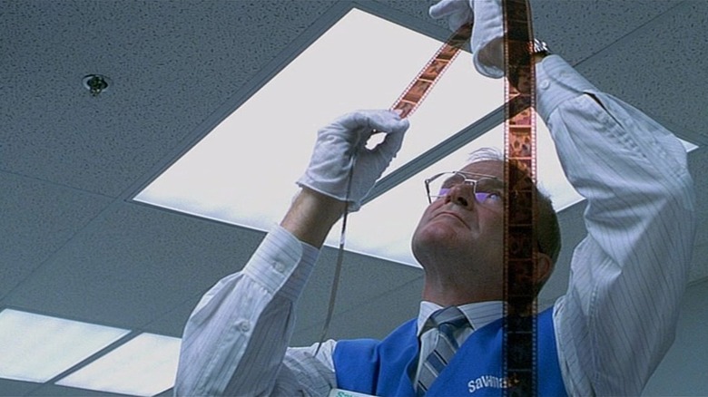 Sy Parrish (Robin Williams) looks at film strips in One Hour Photo