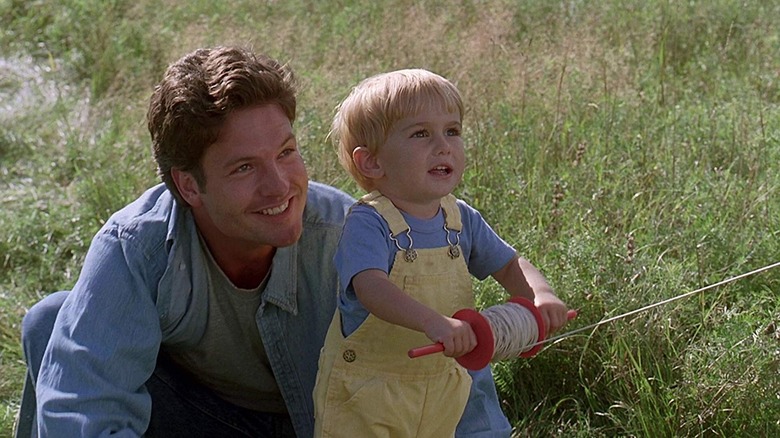 Dale Midkiff as Louis Creed watches Miko Hughes as Gage Creed fly a kite in Pet Sematary