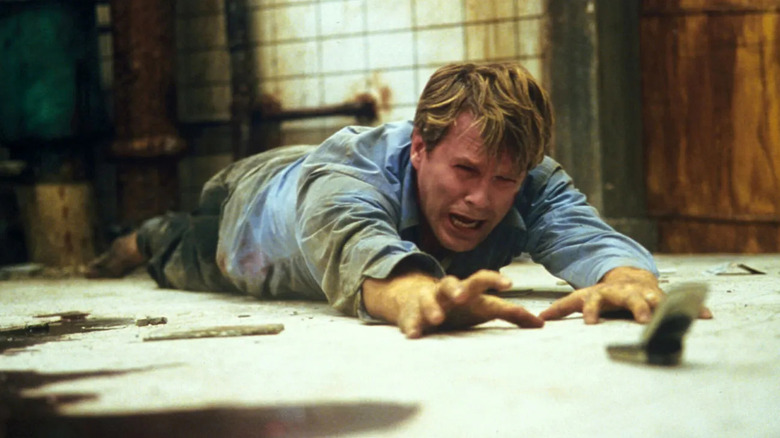 Cary Elwes as Dr. Lawrence Gordon reaches for a phone in Saw