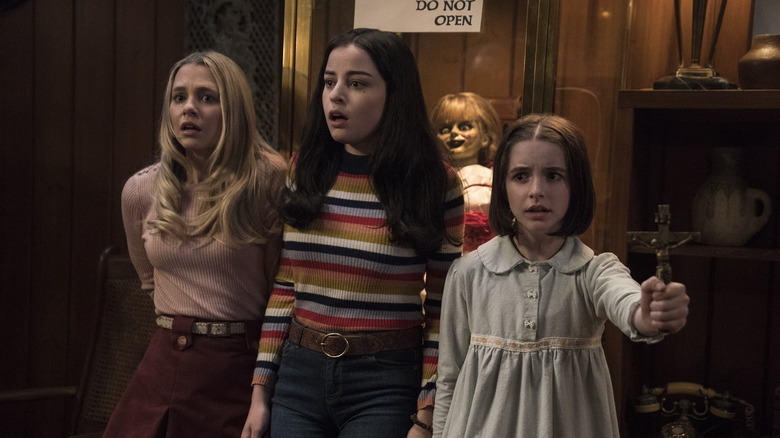 Mary Ellen, Danielle, and Judy huddle together in fear in Annabelle Comes Home