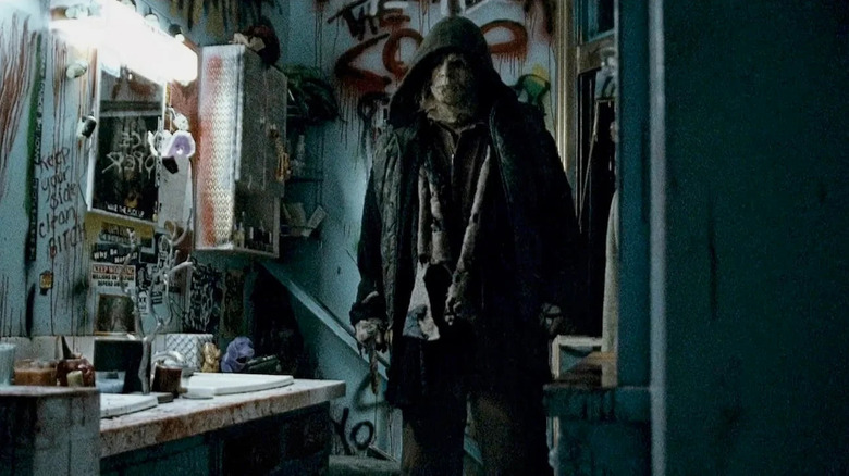 Michael Myers wears a hoodie in a dirty bathroom in Halloween II