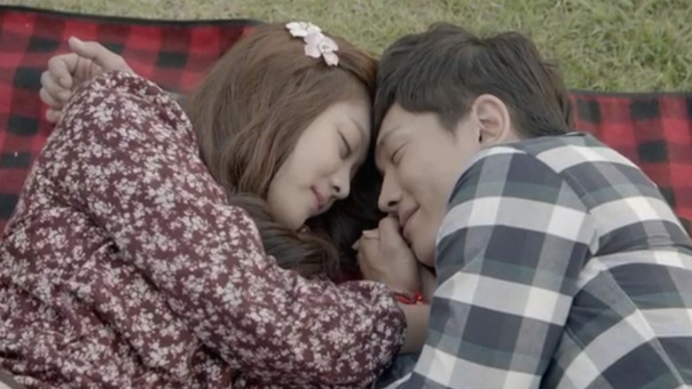 Aileen (Jo Bo-ah) and Lee Hyun-myung (On Joo-wan) cuddle on blanket outside in The Idle Mermaid