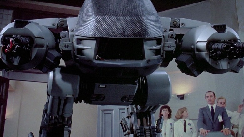 ED-209 readies its guns in front on an audience in RoboCop