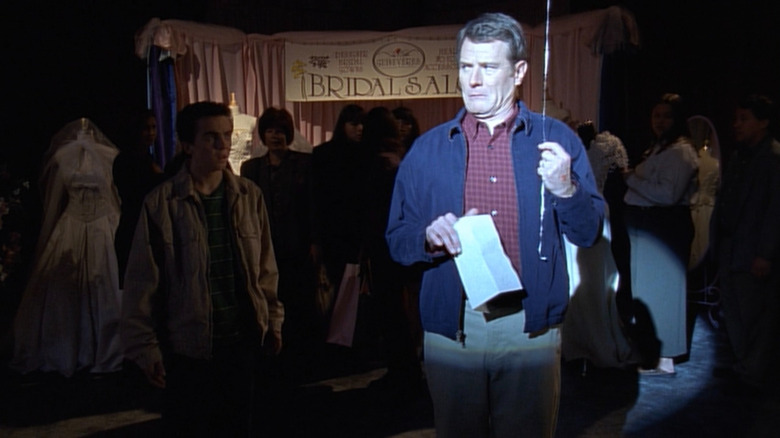 Hal (Bryan Cranston) holding a balloon while Malcolm (Frankie Muniz) watches on Malcolm in the Middle