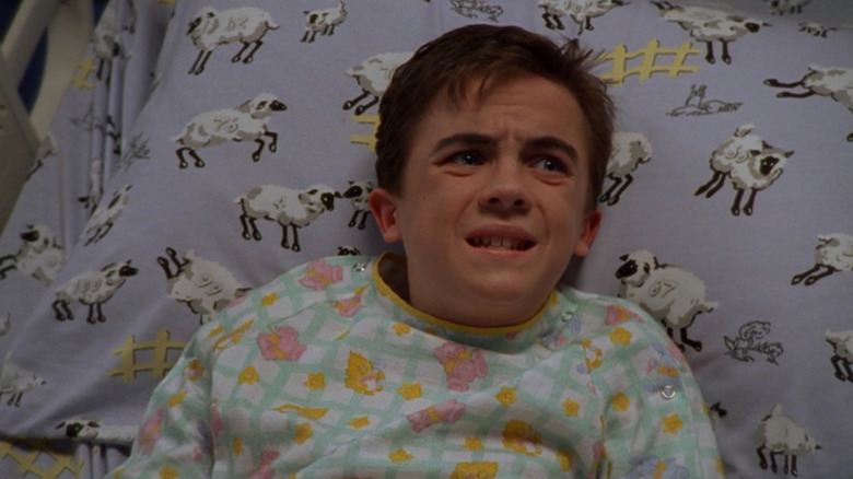 Malcolm (Frankie Muniz) lying in a hospital bed on Malcolm in the Middle