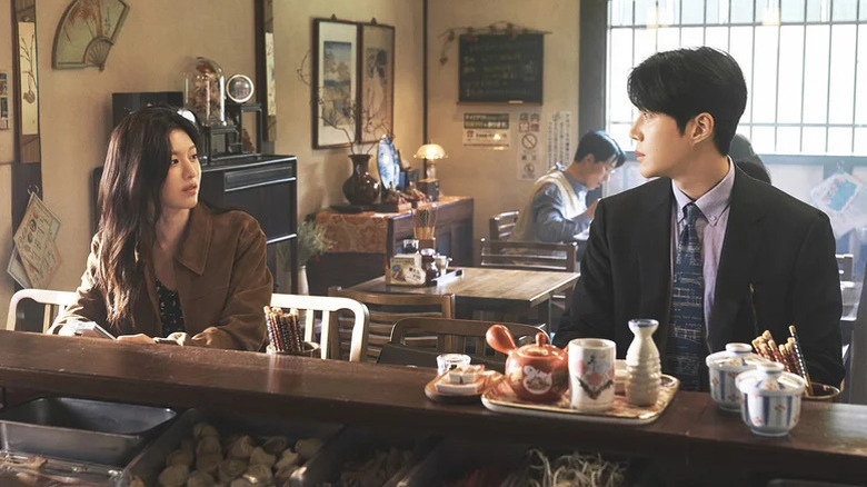Cha Mu-hee (Go Youn-jung) and Joo Ho-jin (Kim Seon-ho) glance at each other at a restaurant counter in Can This Love Be Translated?